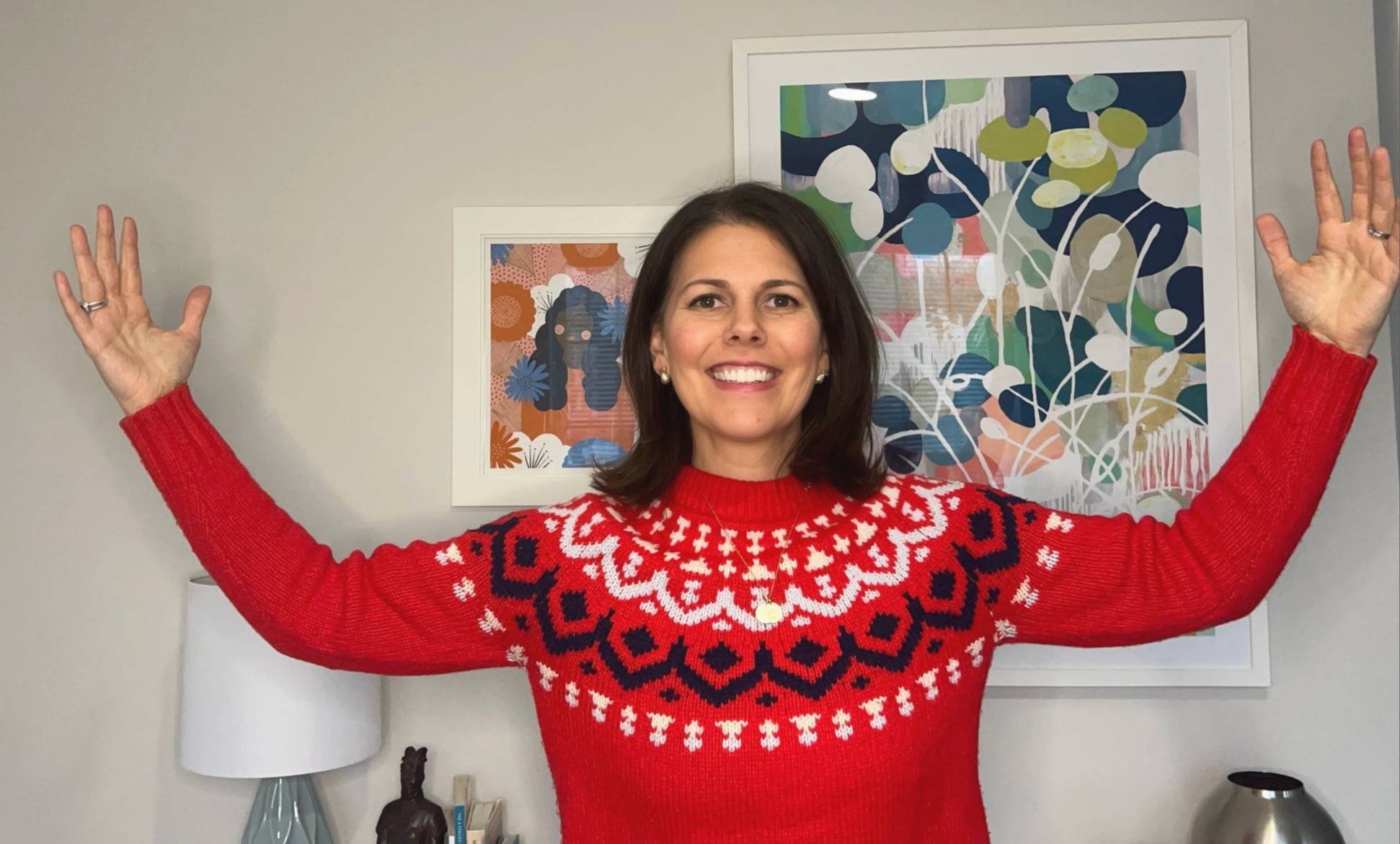 Smiling leadership coach with arms raised in celebration, reflecting on success and mindset