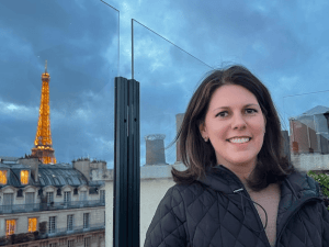 Leadership coach in Paris with the Eiffel Tower in the background, reflecting on leadership and systems