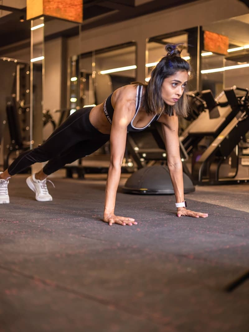 Athletic woman doing push-ups in a gym, symbolizing effort, consistency, and structured discipline